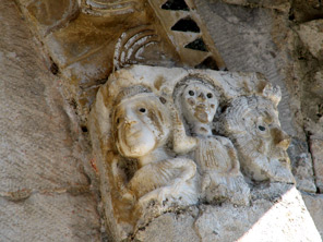 Stazzema (Lucca), chiesa di S. Maria Assunta, facciata: imposta figurata dell'archivolto del portale centrale.